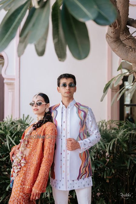 Photo of Couple portrait on mehendi day with bride in a cape outfit and gold parandi look