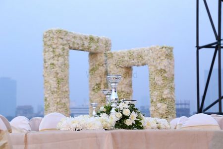 Photo of elegant white centerpieces with white roses and candles