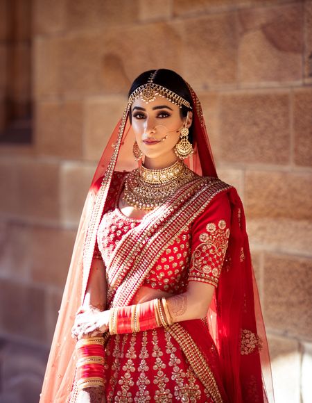 Photo of A bride dressed in a red Sabyasachi lehenga on her wedding day