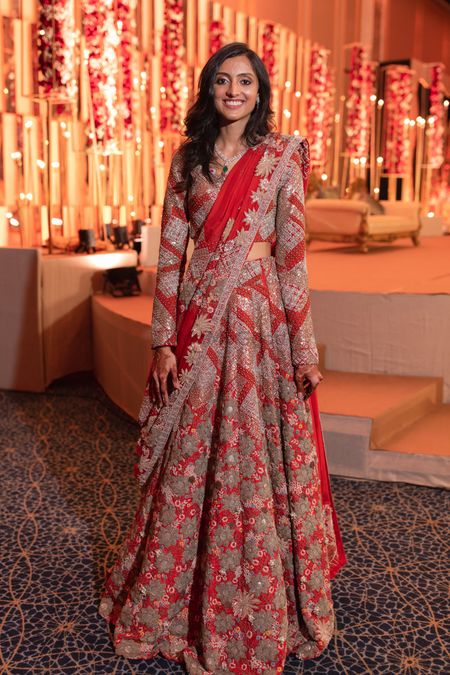 A happy bride dressed in red lehenga at her wedding function