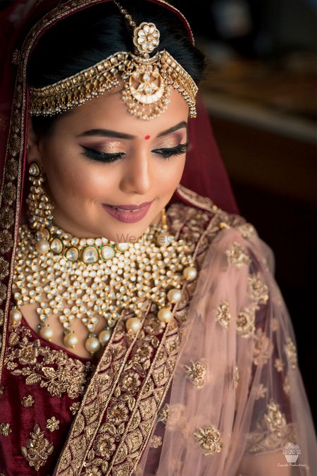 Photo of Pretty gold jewellery with maroon bridal lehenga