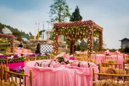 A pink themes wedding with a floral mandap in the background
