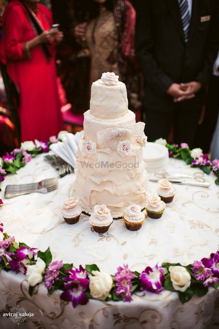 White wedding cake with cupcakes