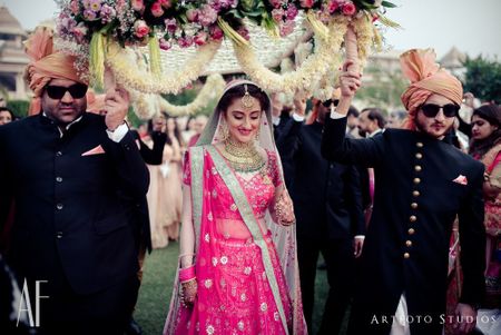 Bride entering under unique phoolon ki chadar