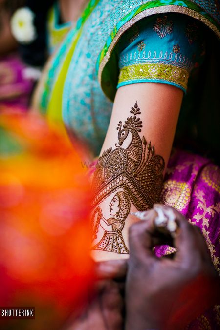 Unique bridal mehendi design with portrait on arm 