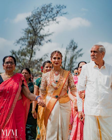 bride entering wedding with her parents for south indian wedding