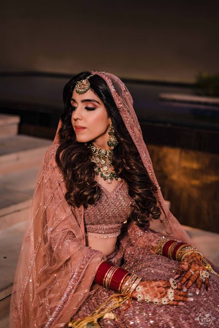 bride with open hair on her wedding day and shimmery lehenga