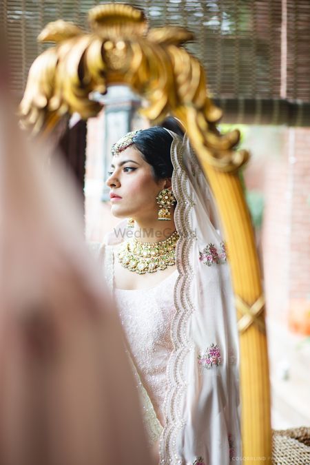 bride looking in mirror wearing scalloped dupatta 