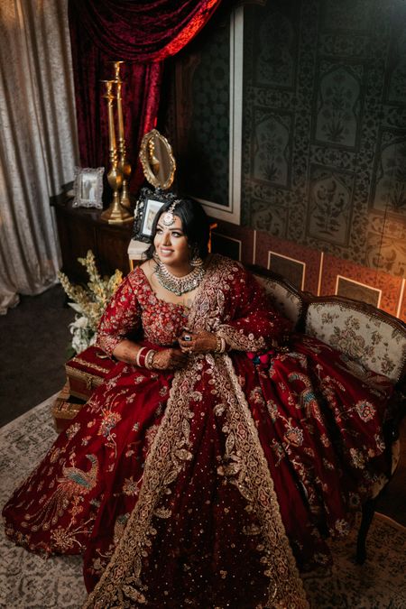 Photo of bride in a heavy maroon rah lehenga