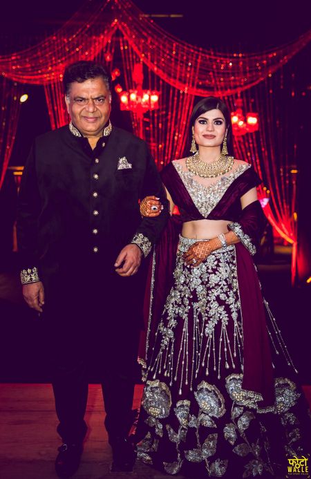 Photo of Bride with father in maroon velvet lehenga and unique blouse