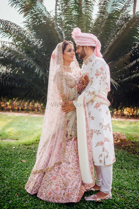 Photo of Matching bride and groom in light pink floral outfits