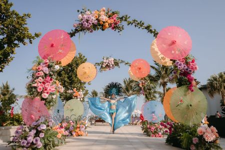 Photo of Colourful entrance decor with parasols and florals for the mehendi ceremony