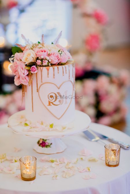 White and pink wedding cake with flowers and monograms