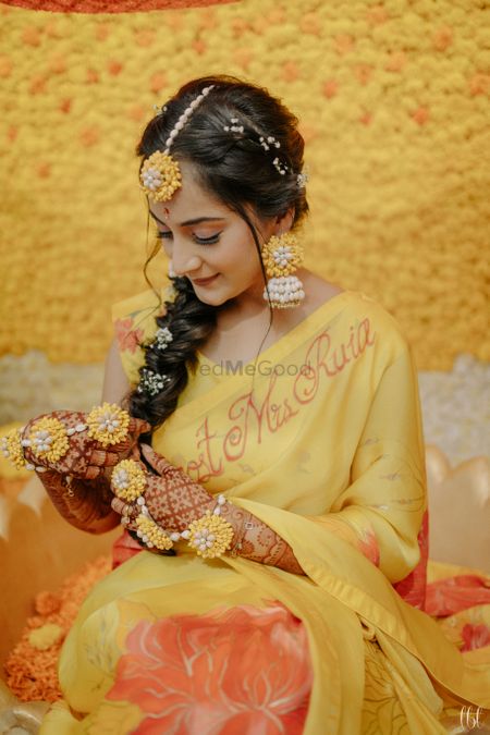 Photo of haldi bridal look with floral jewellery and side braid