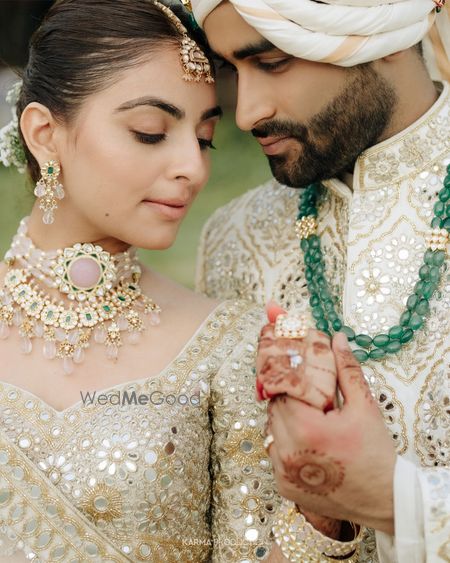 Unique layered jewellery in polki and jadau and groom wearing emerald necklace
