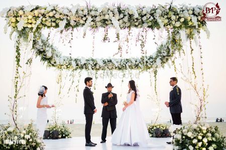 wedding ceremony under white floral mandap
