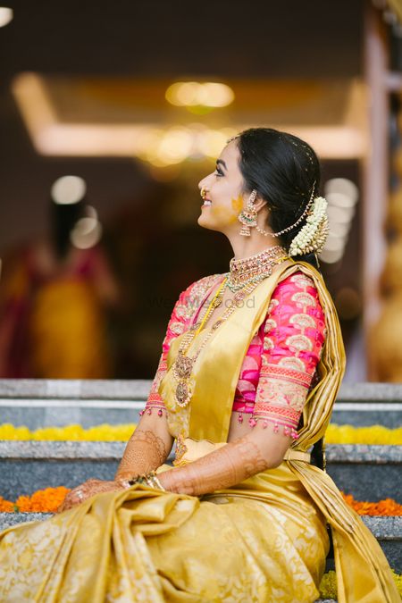 Photo of A happy bridal shot in yellow and gold saree.