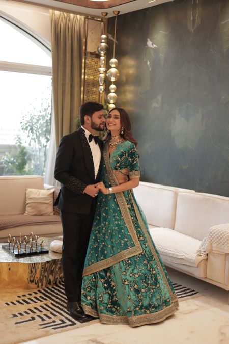 Photo of Cute couple photo with the groom in a tuxedo and bride in a teal blue velvet lehenga