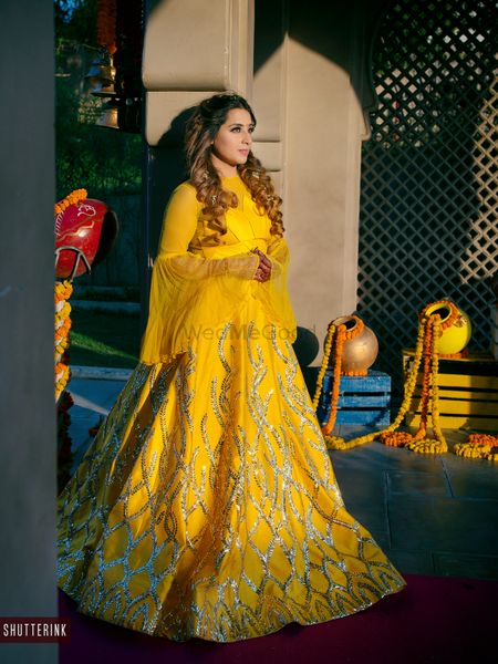 A picture of a bride to be dressed in yellow lehenga