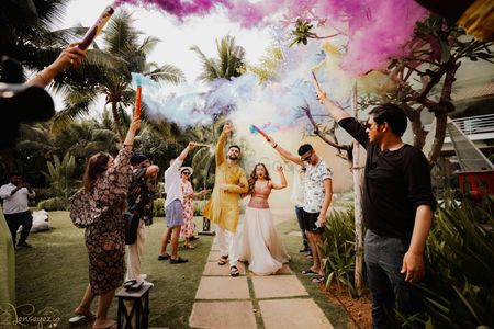 Wedding guest bursting color bombs for couple's entry
