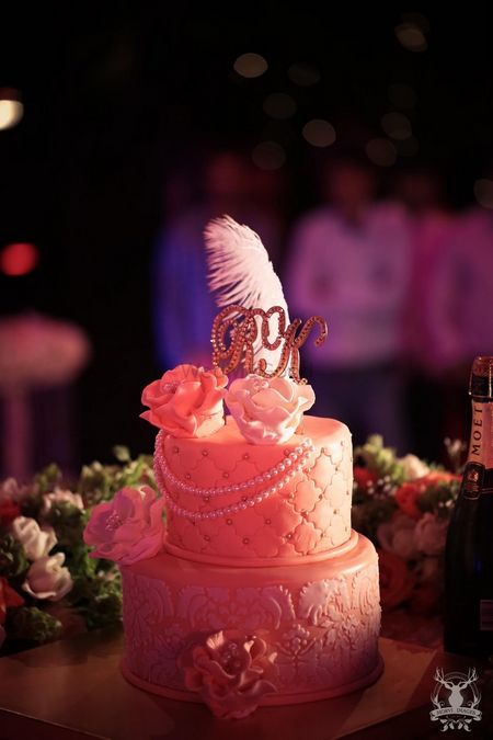 Photo of White two tier cake with feathers on it