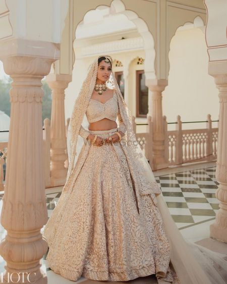 Classic bridal portrait with the bride wearing a stunning white and gold lehenga on her wedding day