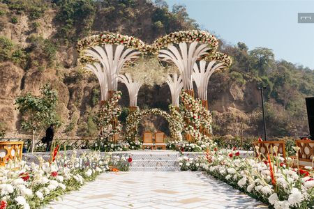 Stunning statement mandap in an outdoor venue with floral detailing and a floral aisle
