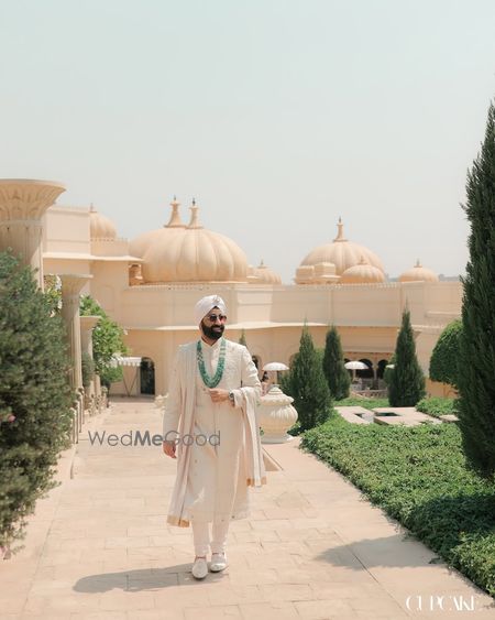 Punjabi grooom in a ivory sherwani and emerald jewellery