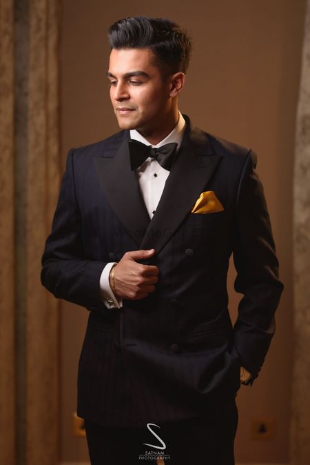 groom in black tux with gold pocket square
