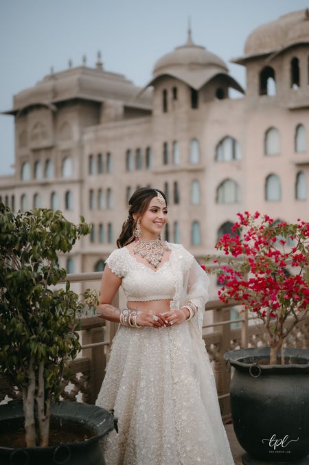 Photo of Lovely bridal day portrait with the bride in all white and colourful wedding jewellery