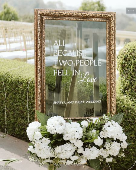 Lovely signage in mirror style with white and green florals for the entrance