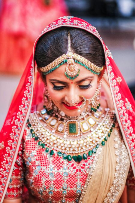 Photo of Heavy bridal green necklace with a red lehenga