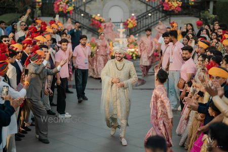 Fun entry of the groom in a sage sherwani and dancing entry