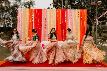 Photo of Bride along with her bridesmaid dancing