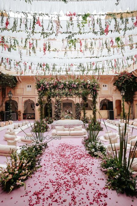 Photo of Gorgeous foliage and floral wedding mandap in an outdoor setting with pink floors
