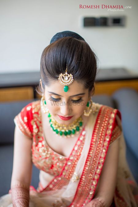 Contrast jewellery in emerald green with red lehenga