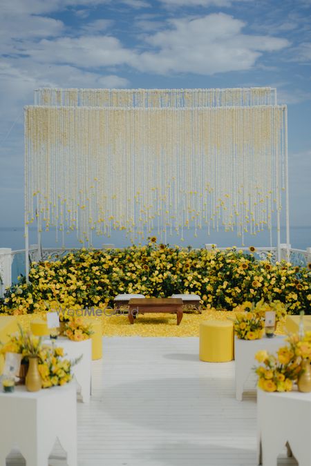 Gorgeous stage setup with yellow florals and hanging floral elements for an outdoor haldi
