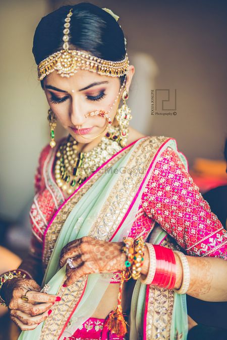 Photo of Bride getting ready in pink and mint lehenga