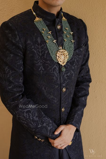 Statement emerald jade necklace for the groom with a black sherwani on his wedding day