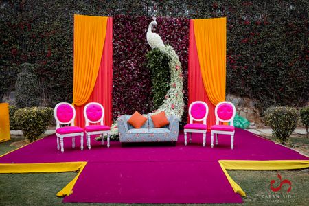 Photo of mehendi stage backdrop with peacock prop