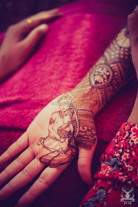 Photo of Intricate mehendi design with bride and groom
