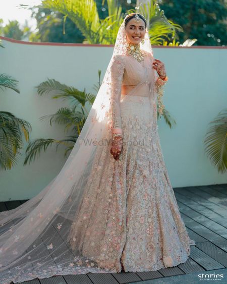 Pastel pink lehenga with a veil style dupatta and statement bridal jewellery
