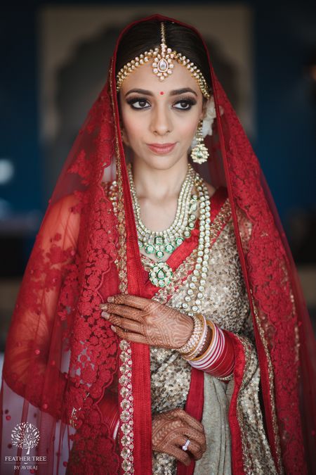 Wedding day bridal portrait idea in red and gold lehenga 