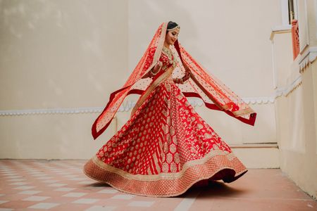 Red and gold sabyasachi bridal lehenga twirling 