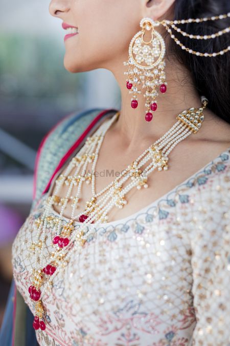 Bride wearing a beautiful panchlada with a pair of matching waterfall earrings.