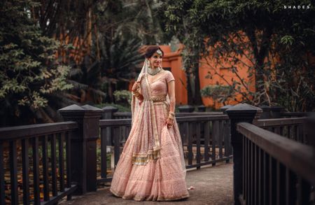Photo of A bride in a soft pink lehenga and double dupatta