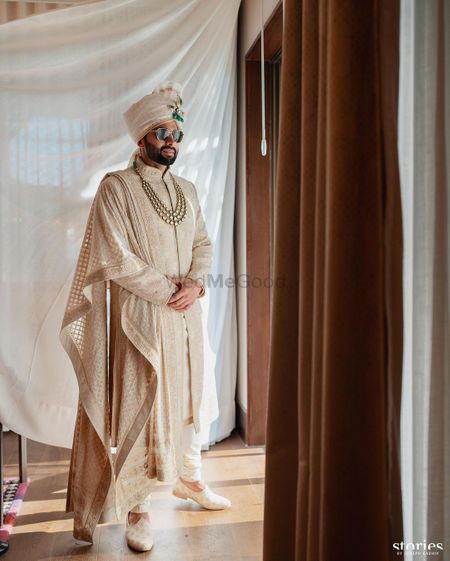 Photo of Timeless groom portrait with a emerald kalgi and lovey offwhite sherwani