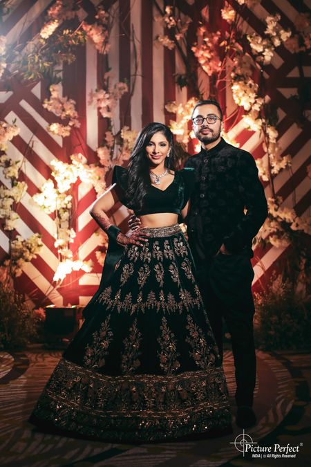 Photo of matching bride and groom in black on their sangeet