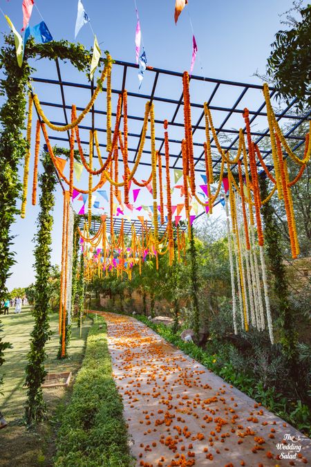Photo of colourful mehendi decor idea with floral strings hanging