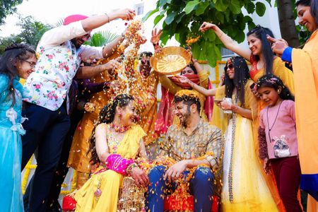 Bride & groom showered with flowers on Haldi 